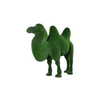 Atlas, a life-size two-hump camel topiary sculpture in artificial grass, sculpted with grounded presence for the Journey Collection.
