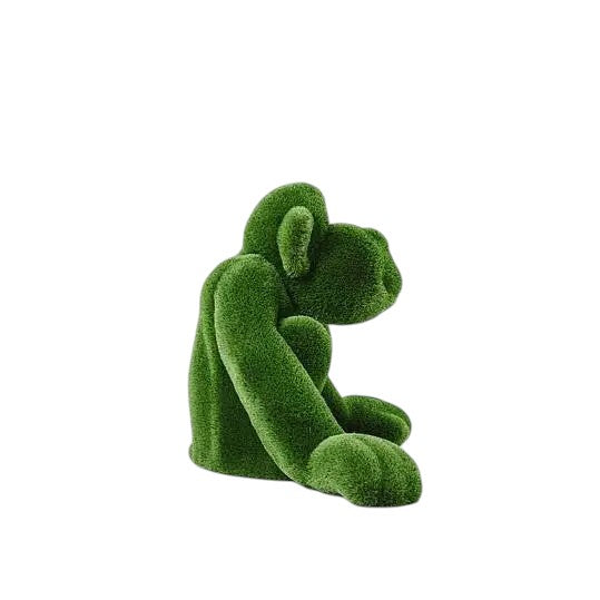 Jubilant, a large seated monkey topiary sculpture in artificial grass, posed with hands on the ground as part of the Guardians Collection.