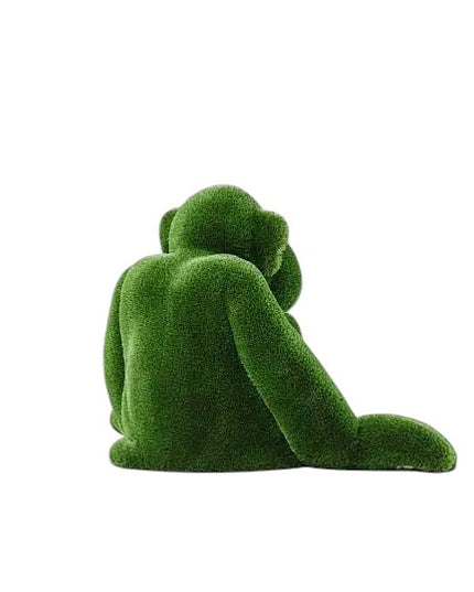 Jubilant, a large seated monkey topiary sculpture in artificial grass, posed with hands on the ground as part of the Guardians Collection.