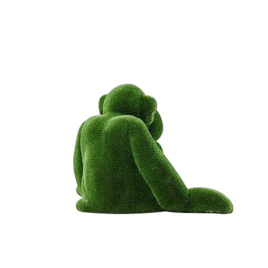 Jubilant, a large seated monkey topiary sculpture in artificial grass, posed with hands on the ground as part of the Guardians Collection.