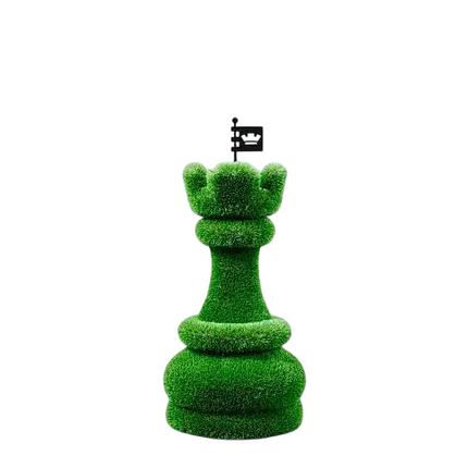 Oversized topiary chess sculptures made of artificial grass, including individual rook castle piece.

