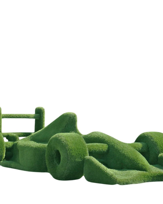 Life-size F1 car sculpture wrapped in artificial grass, designed as a botanical performance piece

